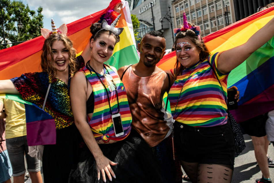 Mit Regenbogen-Fahnen ziehen Teilnehmer der CSD-Parade durch die Stadt.