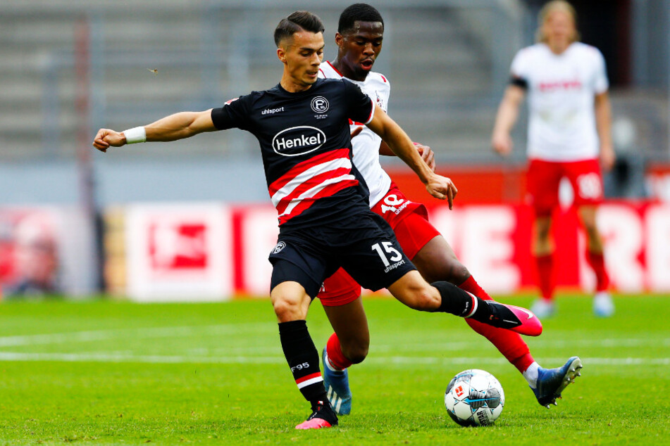 Düsseldorfs Torschütze zum 2:0, Erik Thommy (l.), wird von Kölns Kingsley Ehizibue attackiert.