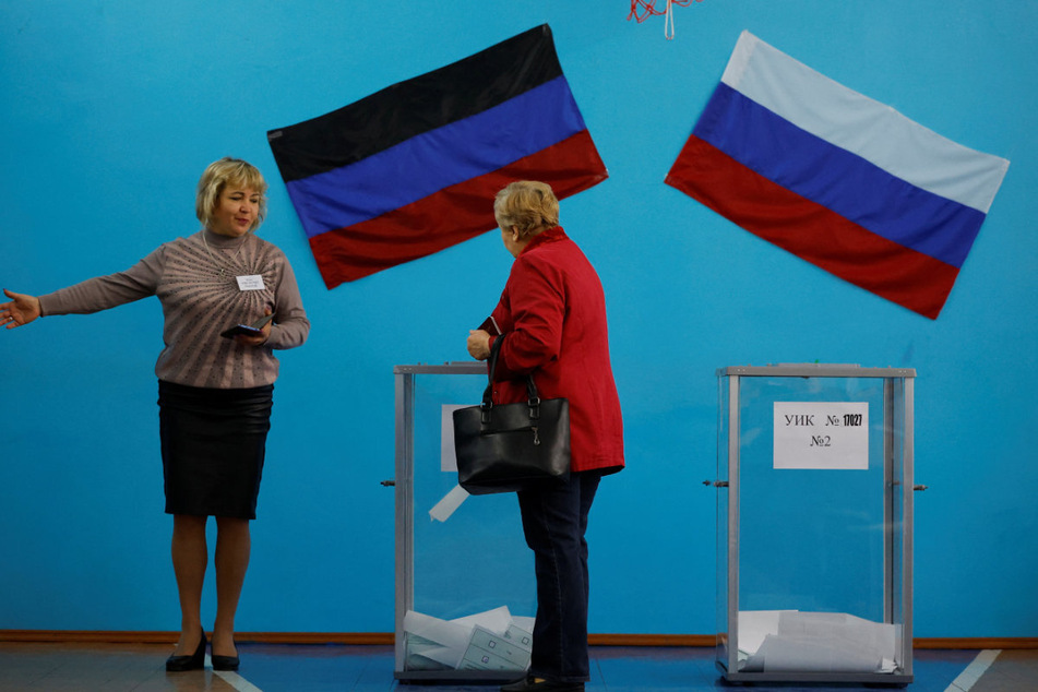 An election official in Donetsk showing a voter the way.