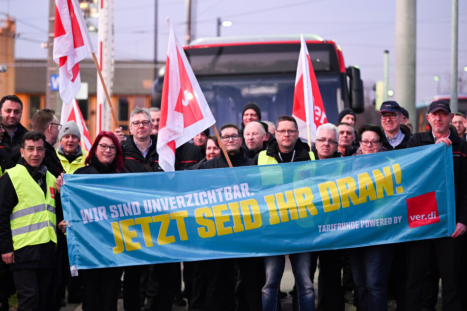 Streikende Mitarbeiter der Rheinbahn stehen auf dem Betriebshof Lierenfeld vor einem Bus.