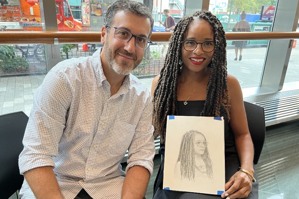 Artist Mark Loughney and exhibition curator Nicole Fleetwood pose after he drew her portrait during the Marking of Time: Art in the Age of Mass Incarceration exhibit at Schomburg Center for Research in Black Culture in New York.