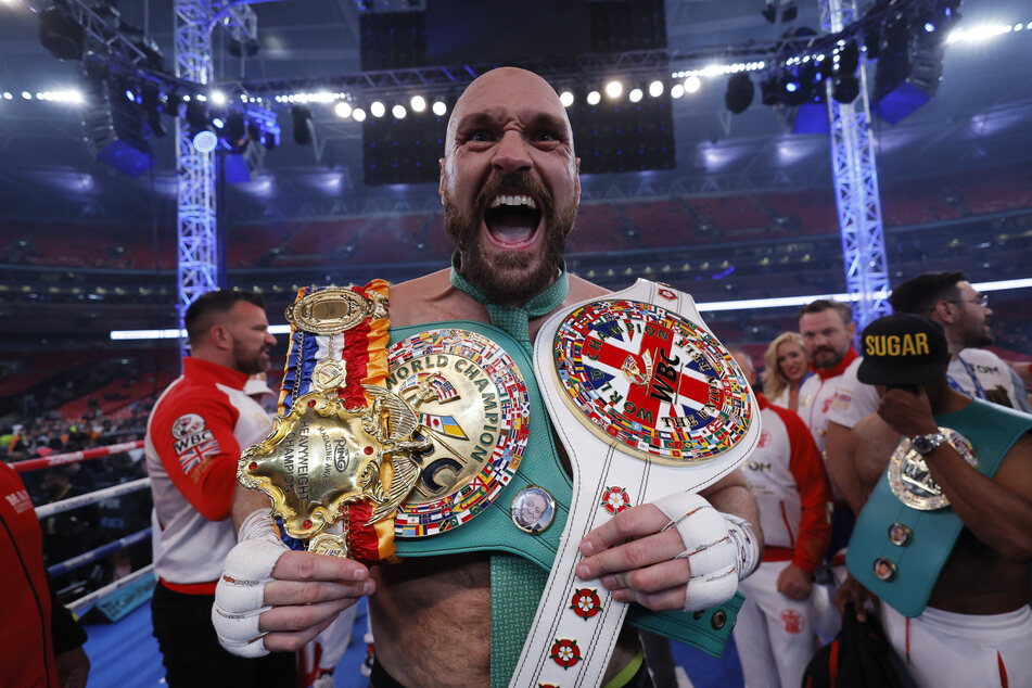 Fury celebrates with his belts at the end of the WBC title fight.