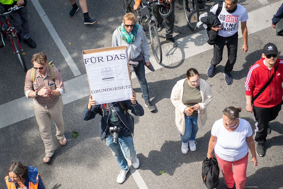 Ein Mann hält während einer Demonstration der Initiative "Querdenken 711" gegen die Corona-Maßnahmen ein Schild, auf dem "Für das Grundgesetz" steht, hoch.