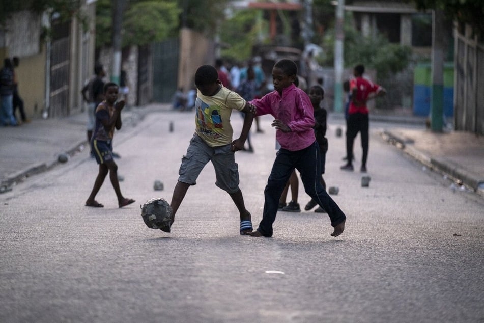 Haitian children play soccer in the street in Port-au-Prince.