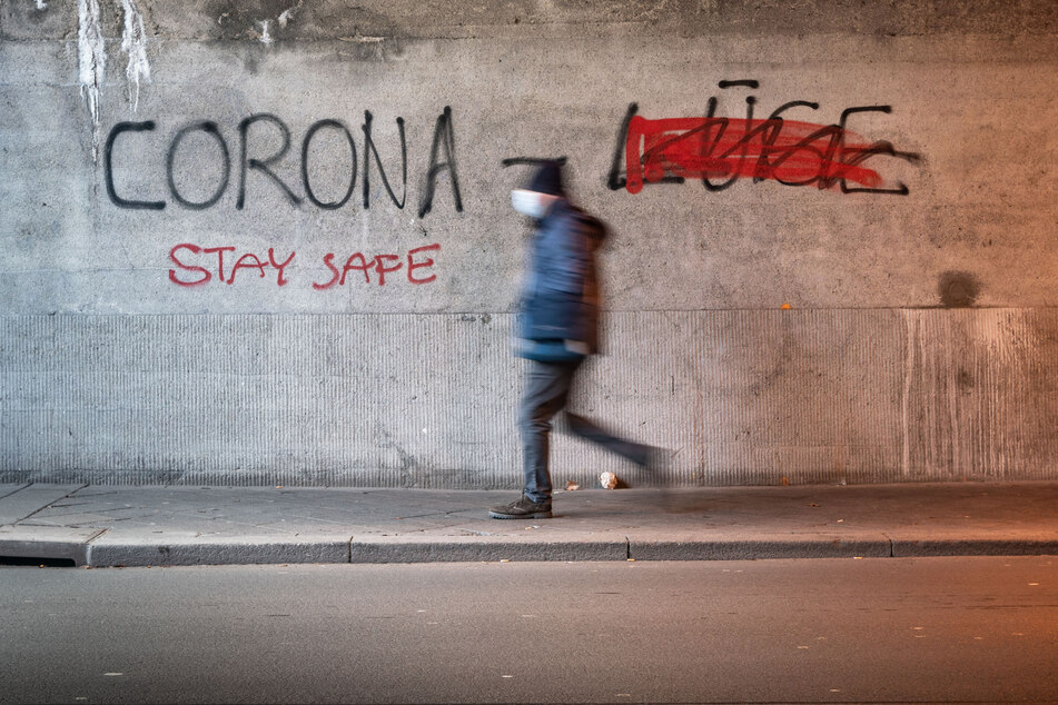 An einer Wand steht "Corona Lüge", wobei das Wort "Lüge" (r.) durchgestrichen wurde. Weil viele Menschen in Zeiten der Pandemie verunsichert sind, hat die Landesberatungsstelle in Essen zahlreiche Anfragen zu Verschwörungstheorien erhalten.