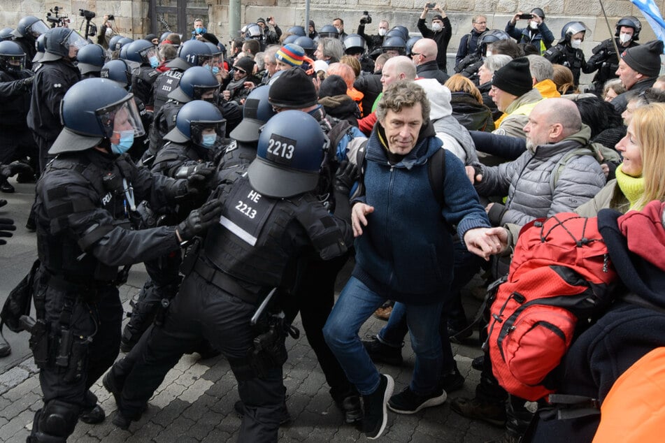 Einsatzkräfte der Polizei halten bei einer Kundgebung unter dem Motto "Freie Bürger Kassel - Grundrechte und Demokratie" Teilnehmer zurück.