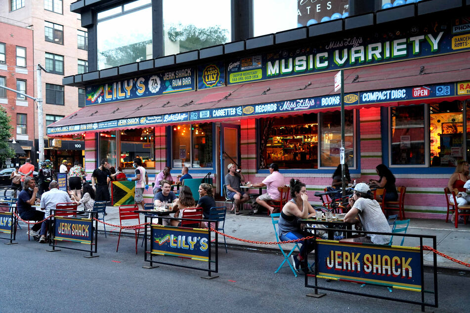 Gäste des Restaurants "Miss Lily's" sitzen an Tischen vor der Gaststätte in Lower Manhattan in New York.