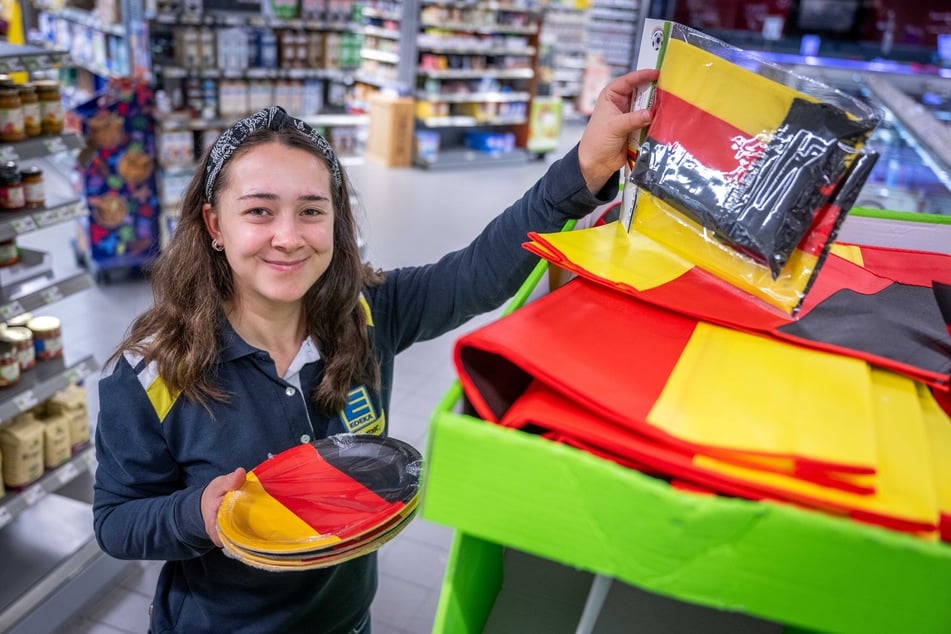Im Edeka in der Ermafa-Passage zeigt Mitarbeiterin Charleen Treichel (18) die Fanartikel für die Fußball-WM.
