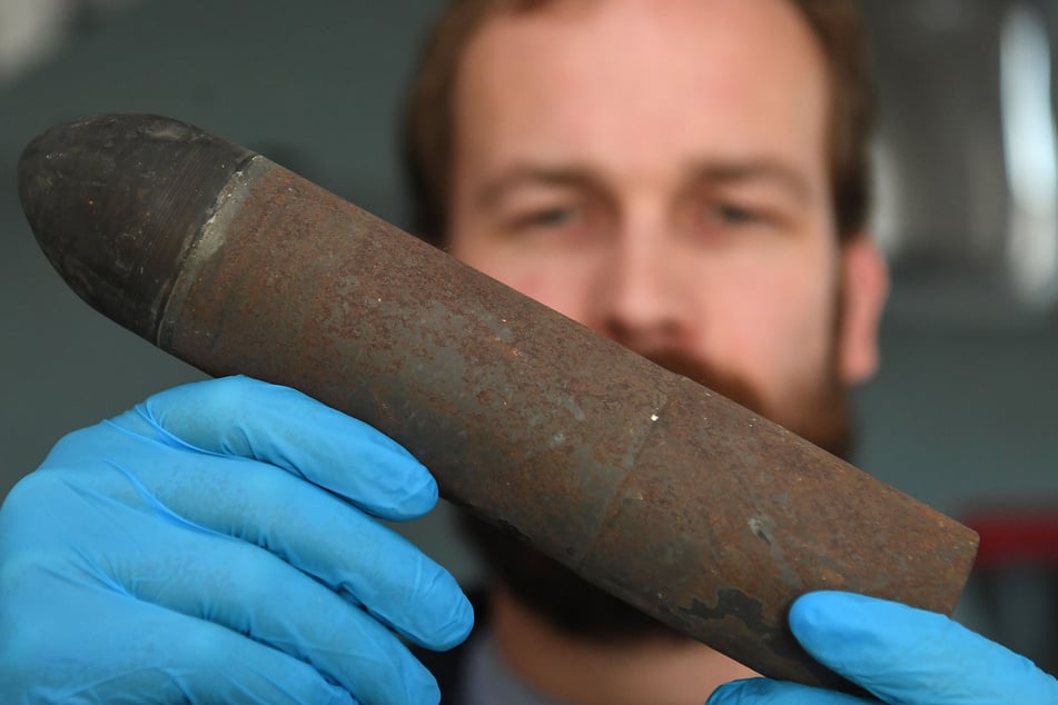 Philipp Grassel vom Schifffahrtsmuseum Bremerhaven hält eine Geschosshülse in seinen Händen. Das Museum widmet sich der Erforschung von Kriegshinterlassenschaften.
