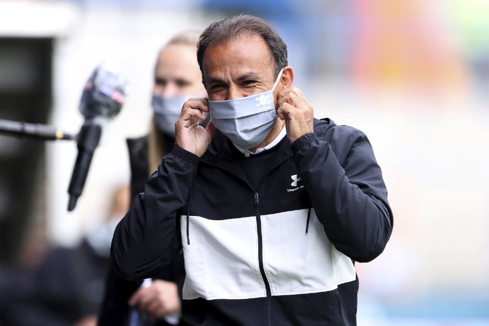 Jos Luhukay (56), Trainer vom FC St. Pauli, setzt sich eine Maske auf.