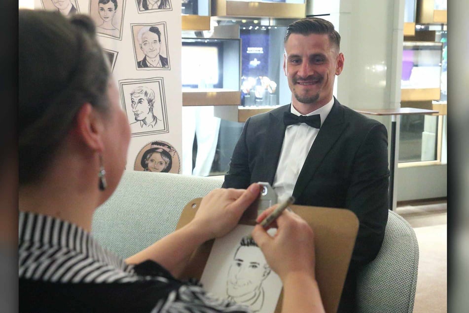Dynamo-Kicker Stefan Kutschke (37) lässt sich von Illustratorin Paula Huhle (45) zeichnen.