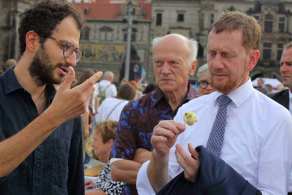 Darfs etwas vom Halawet el jiben sein? Abed Sarraf (33) lässt MP Michael Kretschmer (47, r.) naschen.