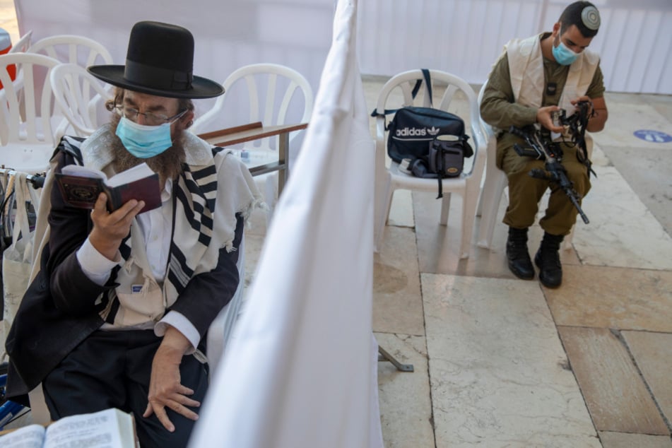 Jerusalem: Ein ultra-orthodoxer jüdischer Mann betet unter Einhaltung eines Mindestabstands und mit einem Mund-Nasen-Schutz nahe eines israelischen Soldaten vor dem jüdischen Vergebungstag Jom Kippur.