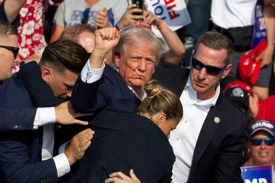 Secret Service agents surround Donald Trump on stage after a failed assassination attempt at a Republican presidential campaign rally in Butler, Pennsylvania.