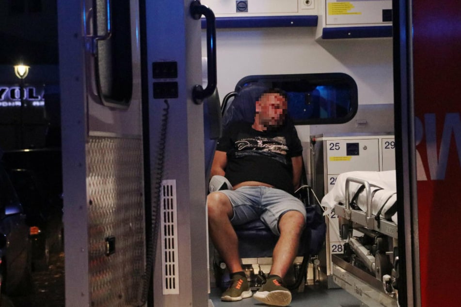 Einer der Insassen sitzt mit blutigem Gesicht in einem Rettungswagen.