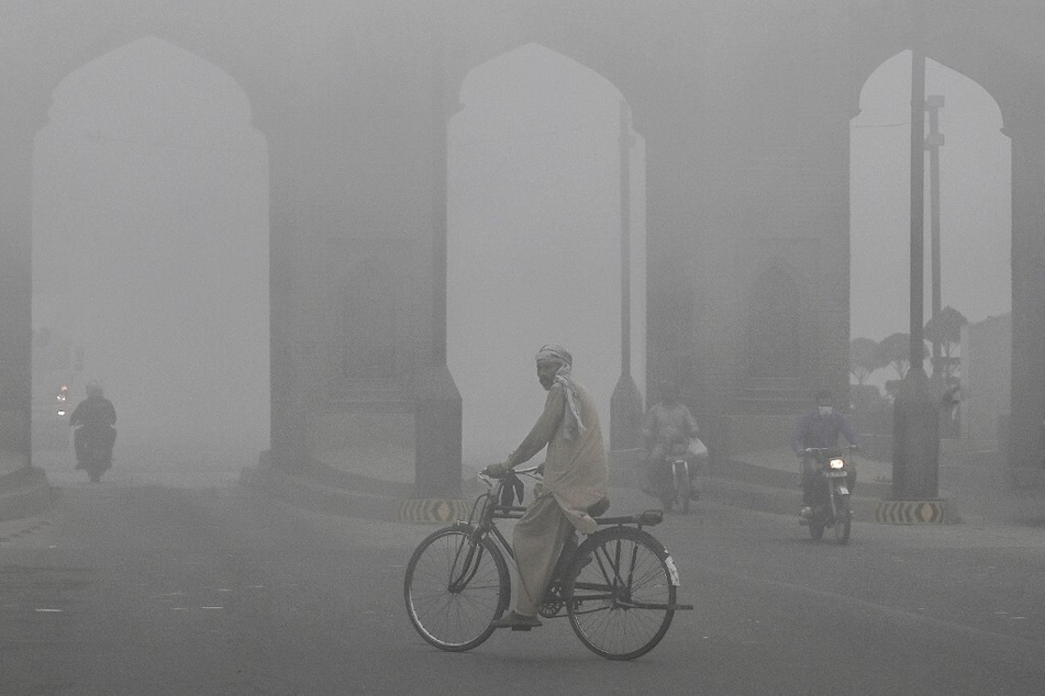 A cyclist rides along a street engulfed in thick smog in Lahore, Pakistan, on November 10, 2024.