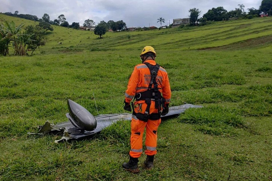 Ein Feuerwehrmann begutachtet eines der Flugzeugteile der abgestürzten Maschine.