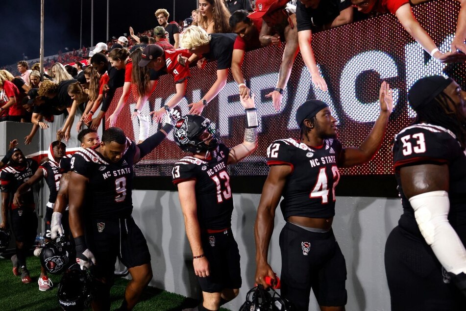 The NC State Wolfpack high-fives fans following their win in their home game against the Texas Tech Red Raiders.