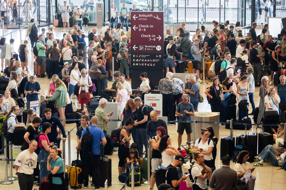 Reisende warten am Hauptstadtflughafen BER auf die Abreise.