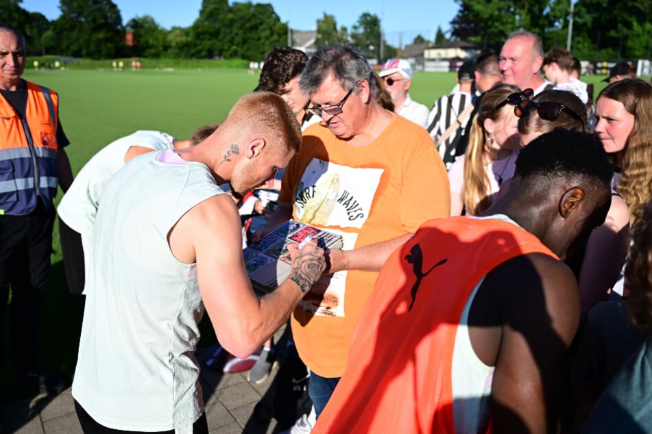Nach der Einheit gingen die Kiezkicker auf Tuchfühlung mit den Fans. Hier erfüllt Louis Oppie (24, l.) einen Autogrammwunsch.