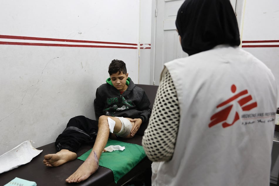 An injured Palestinian boy is seen to by a member of staff at a Doctors Without Borders clinic in the al-Rimal neighborhood of Gaza City on December 31, 2025.