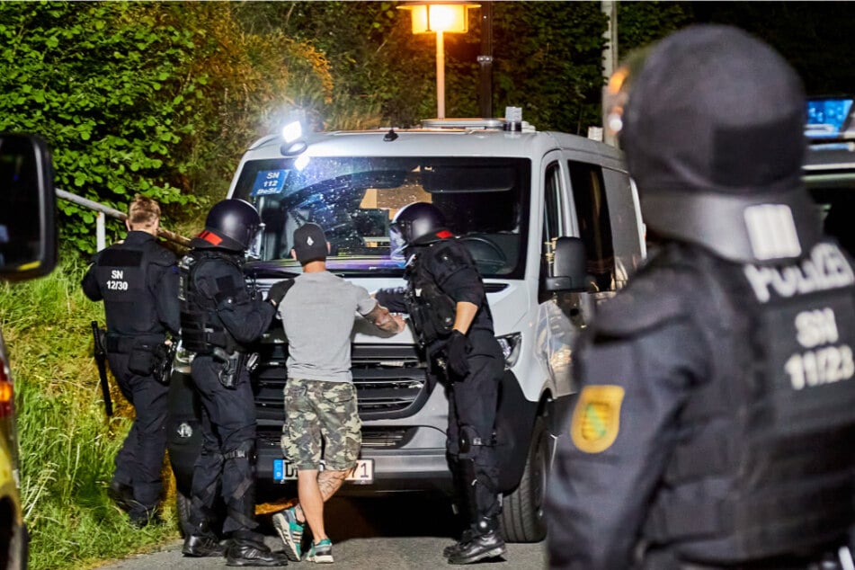 Polizeibeamte mit einer vorläufig festgenommenen Person.