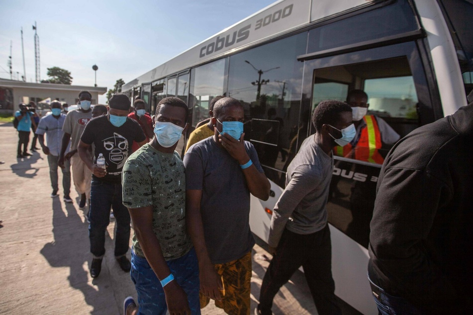 Haitian migrants get off a bus after being deported from the United States.