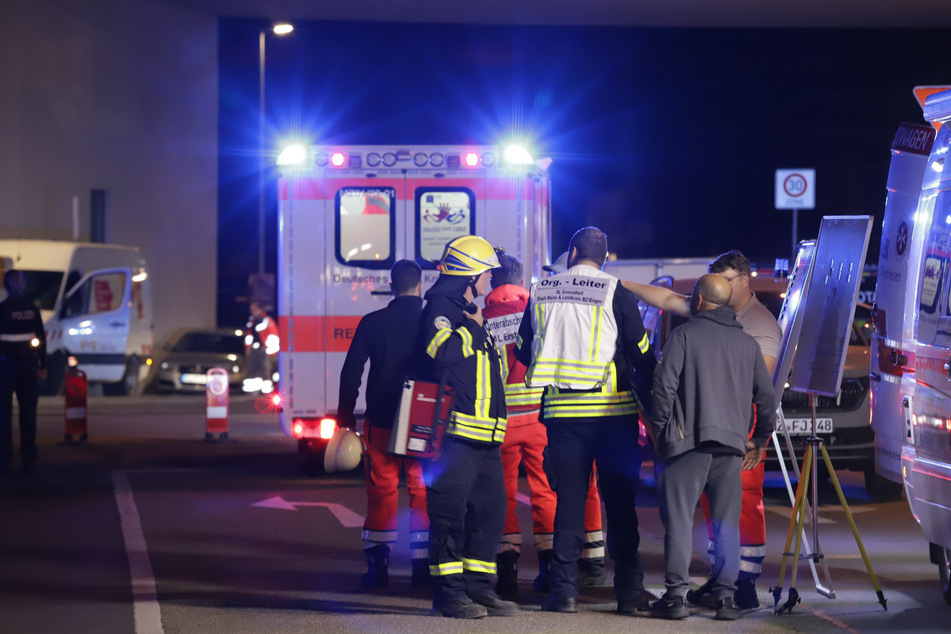 Zahlreiche Personen mussten aufgrund des Brands in einem Mainzer Hochhaus evakuiert werden. Später wurden sie auf der Straße vor dem Gebäude von den Einsatzkräften betreut.