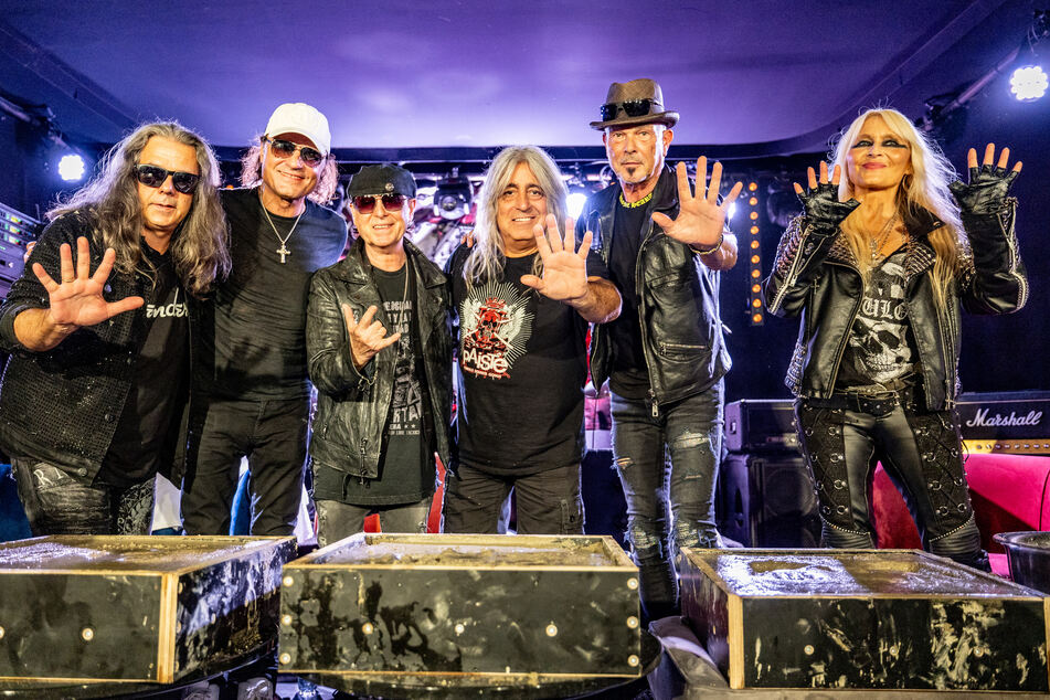 Die Scorpions und Metal-Queen Doro Pesch (60, r.) zeigen ihre Hände, nachdem sie sie für den "Walk of Legends" in Beton gedrückt haben. Die Scorpions sind Headliner beim Wacken Open Air.