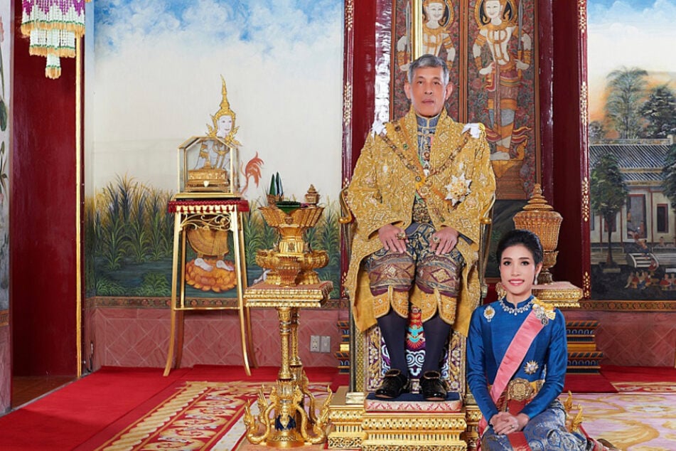 König Maha Vajiralongkorn von Thailand (68) sitz auf seinem Thron, während neben ihm Sineenat Wongvajirapakdi (35) kniet. Die zuvor Verstoßene wurde nun begnadigt.