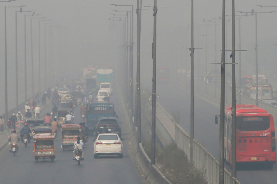 Lahore, Pakistan: Fahrzeuge fahren auf einer Autobahn, während Smog das Gebiet einhüllt.