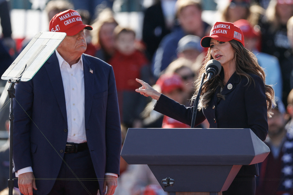 Republican presidential candidate Donald Trump (l.) listening as North Dakota Governor Kristi Noem speaks during a campaign rally in Vandalia, Ohio, on March 16, 2024.