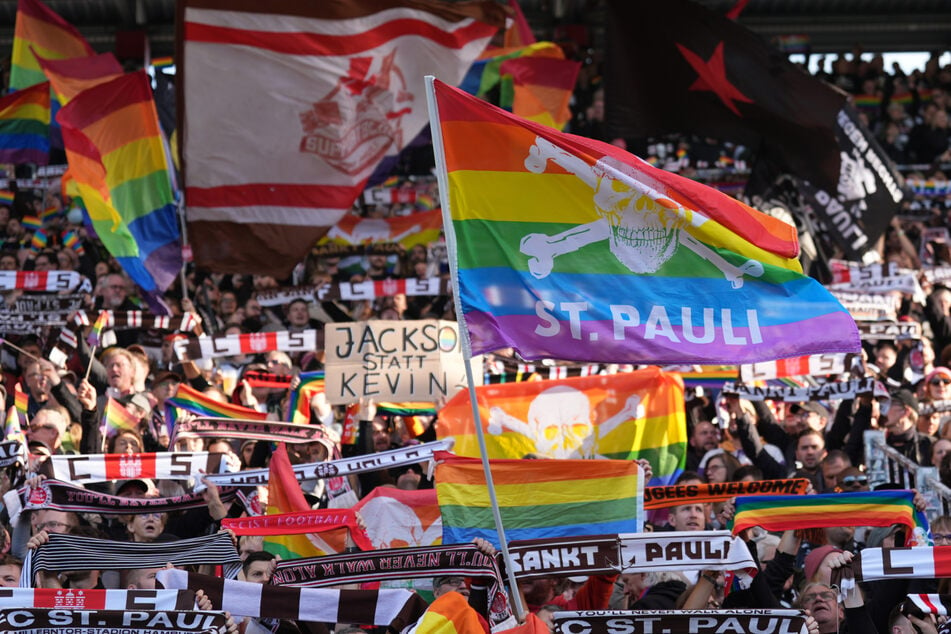 Regenbogen-Fahnen, so weit das Auge reicht: Die Fans des FC St. Pauli schicken im Millerntor-Stadion eine deutliche Nachricht an VfL-Stürmer Kevin Behrens.