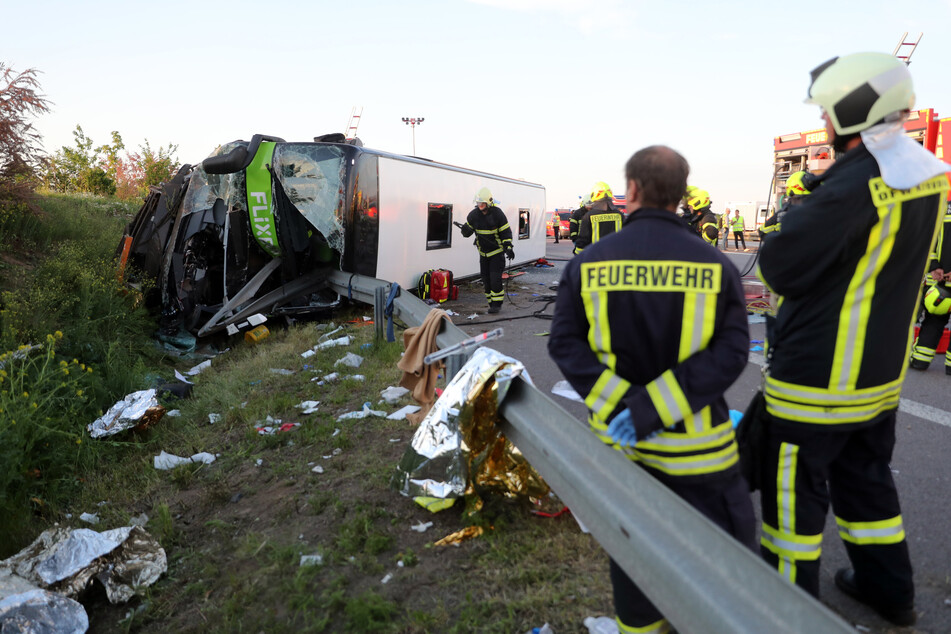 Feuerwehrleute stehen neben dem verunglückten Flixbus, in dem eine Insassin aus Italien starb. (Archiv)