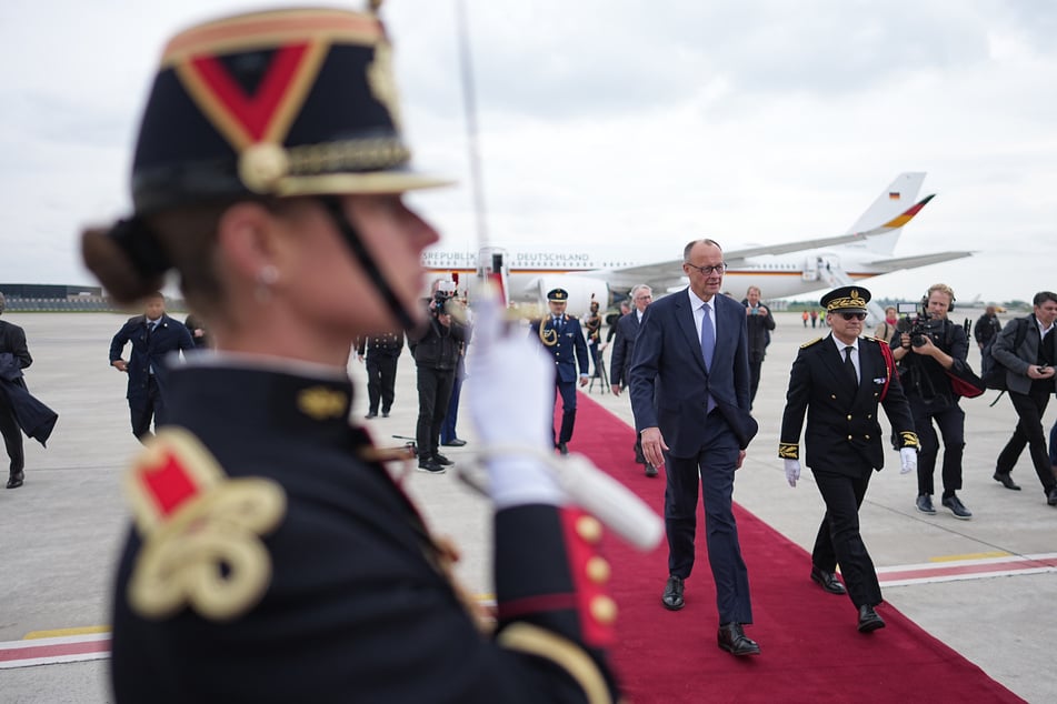 Friedrich Merz (69, CDU) schreitet über den roten Teppich und wird sich nun mit dem französischen Präsidenten Emmanuel Macron (47) unterhalten.