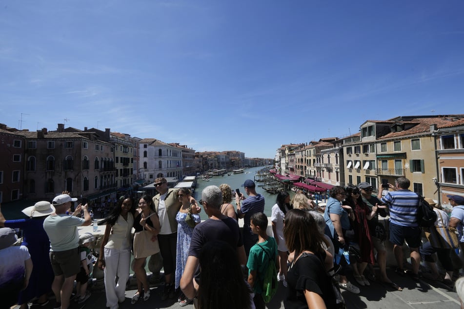 Massentouristen drängen sich auf die Rialto Brücke in Venedig.