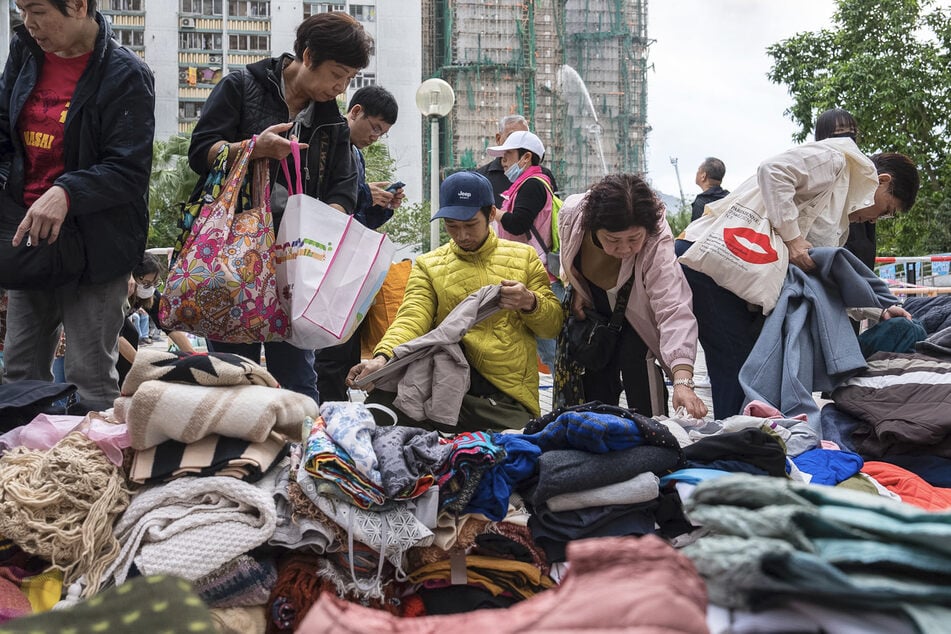 Betroffene Bewohner, die ihr Hab und Gut verloren haben, wühlen sich durch gespendete Kleidung.