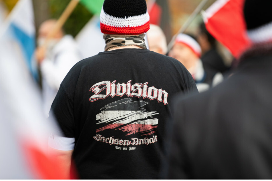 Ein Mann trägt bei einer Demonstration von Reichsbürgern einen Pullover mit dem Aufdruck "Division Sachsen-Anhalt - Treu der Fahne'".