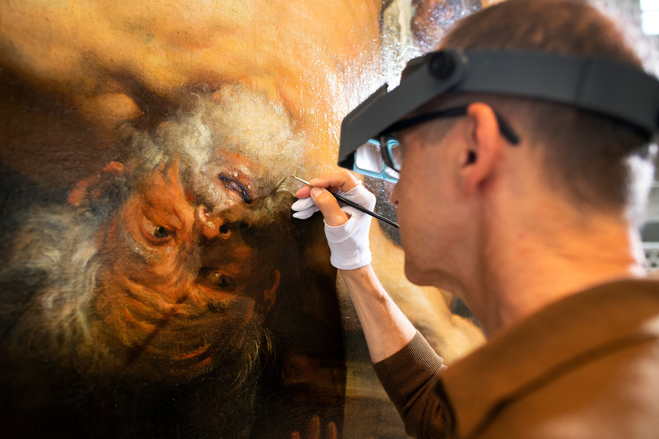 Der Kölner Restaurator Andreas Hoppmann arbeitet am Gemälde "Die Kreuzigung Petri" von Peter Paul Rubens.