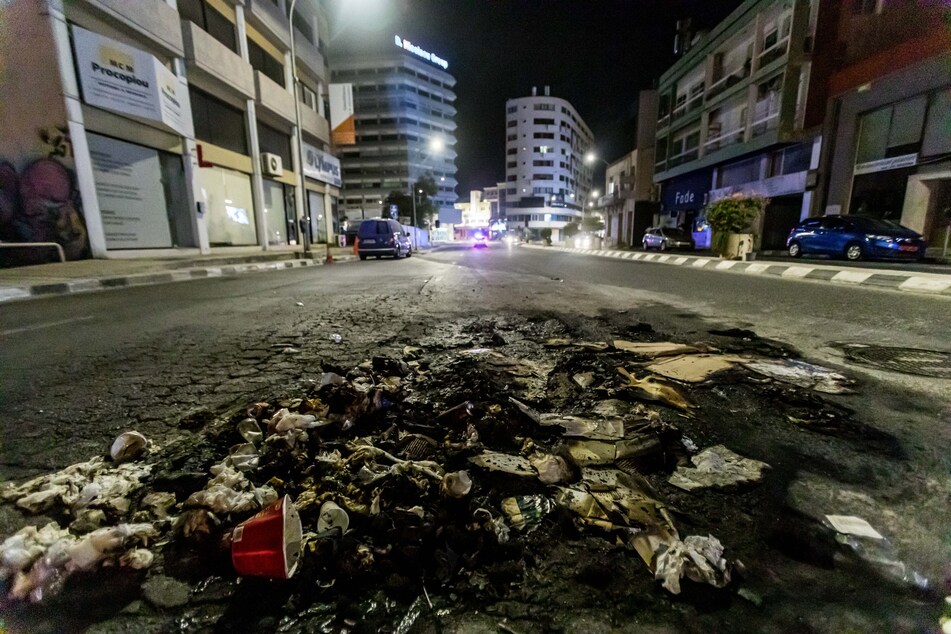 Reste von verbranntem Müll sind nach dem Protest auf der Straße zu sehen.