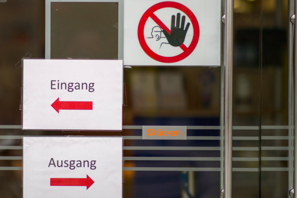 "Eingang" und "Ausgang" sowie ein Durchgangsverbot stehen auf Schildern am Eingang zu einer Bank in der Nürnberger Innenstadt.