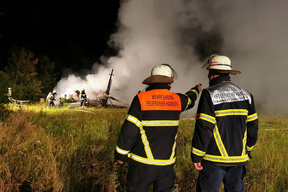 Feuerwehrleute stehen am Einsatzort in Lemsahl-Mellingstedt.