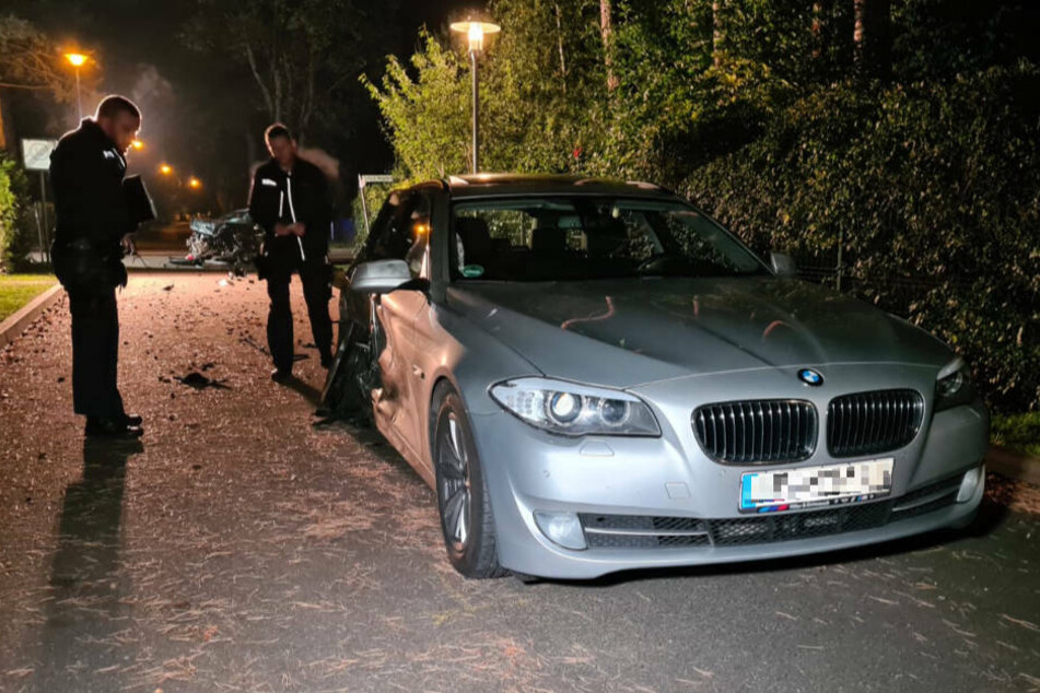 Polizeibeamte stehen neben dem BMW, dessen alkoholisierter Fahrer mit überhöhter Geschwindigkeit über die Kreuzung gerast ist und einem Kleinwagen die Vorfahrt genommen hat. Im Bereich der Hinterachse ist die Einschlagstelle zu erkennen.