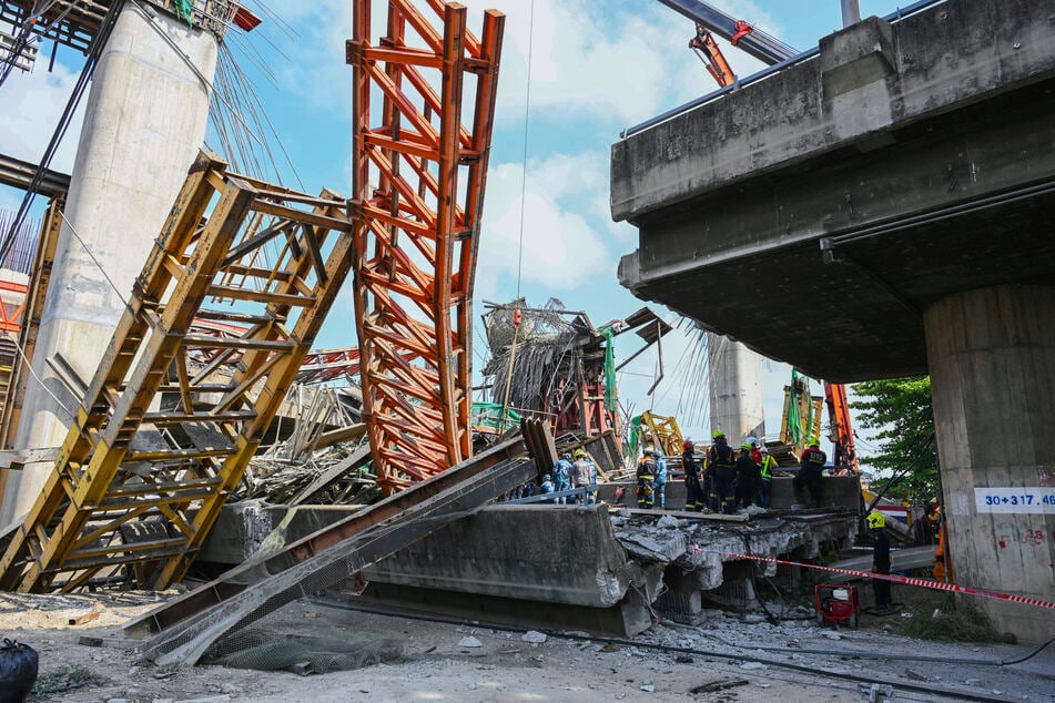 Thailändische Rettungskräfte arbeiten nach dem Einsturz einer Hochstraße an der Unfallstelle.