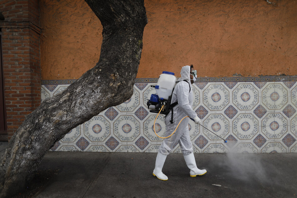 A worker in Mexico City sprays disinfectant on a street against the new corona virus.