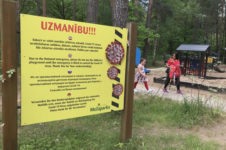 Ein Hinweisschild steht neben einem Spielplatz im beliebten Naherholungsgebiets Mezaparks in der lettischen Hauptstadt Riga.