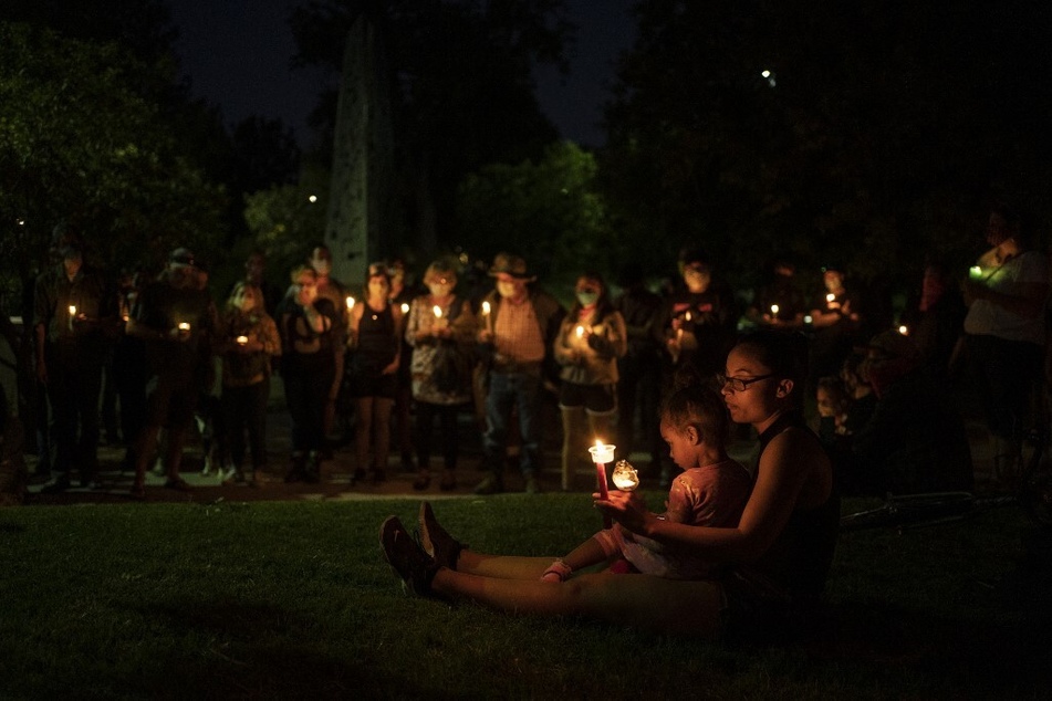 Community members hold a candlelight vigil for Scott Williams, who was shot and seriously injured by counter-protester Steven Baca during a rally to remove a sculpture of conquistador Juan de Oñate at the Albuquerque Museum on June 16, 2020.