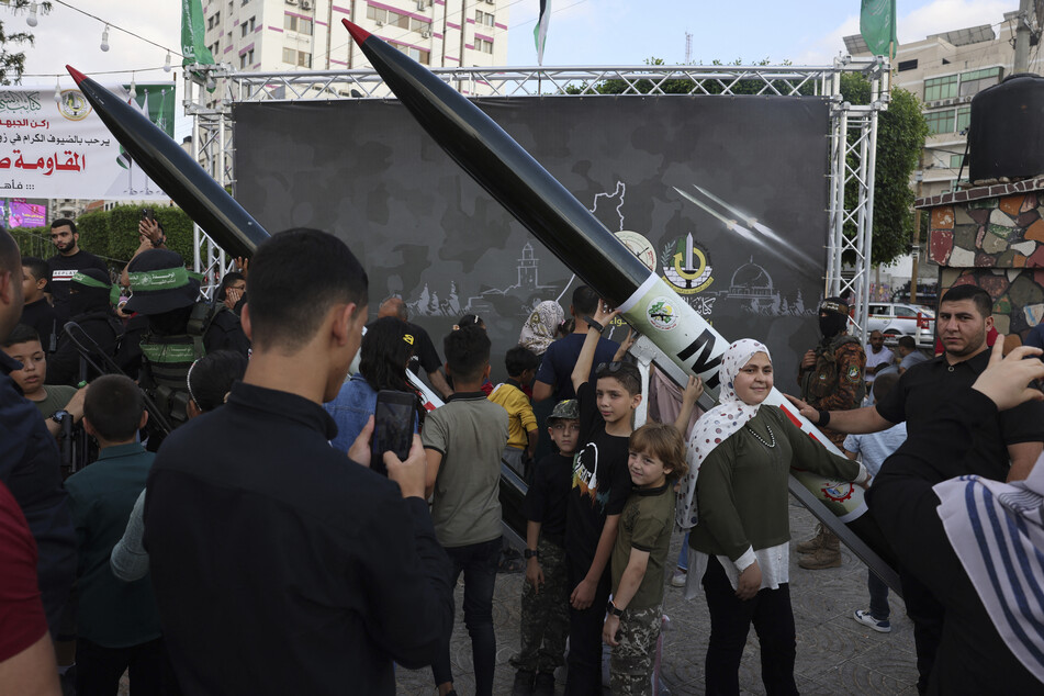 Palestinian children pose for a souvenir picture with an RPG launcher during an exhibition by the Ezzedine al-Qassam Brigades, the military wing of the Palestinian Hamas movement, in Gaza City on June 30, 2023.