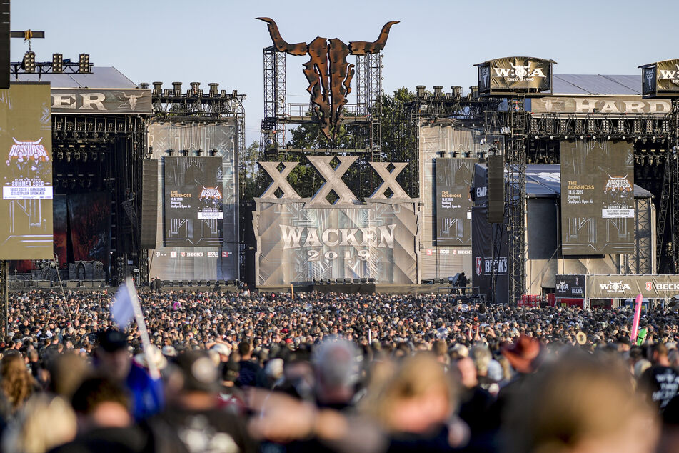 Festivalteilnehmer des WOA (Wacken Open Air) feiern vor den Bühnen.
