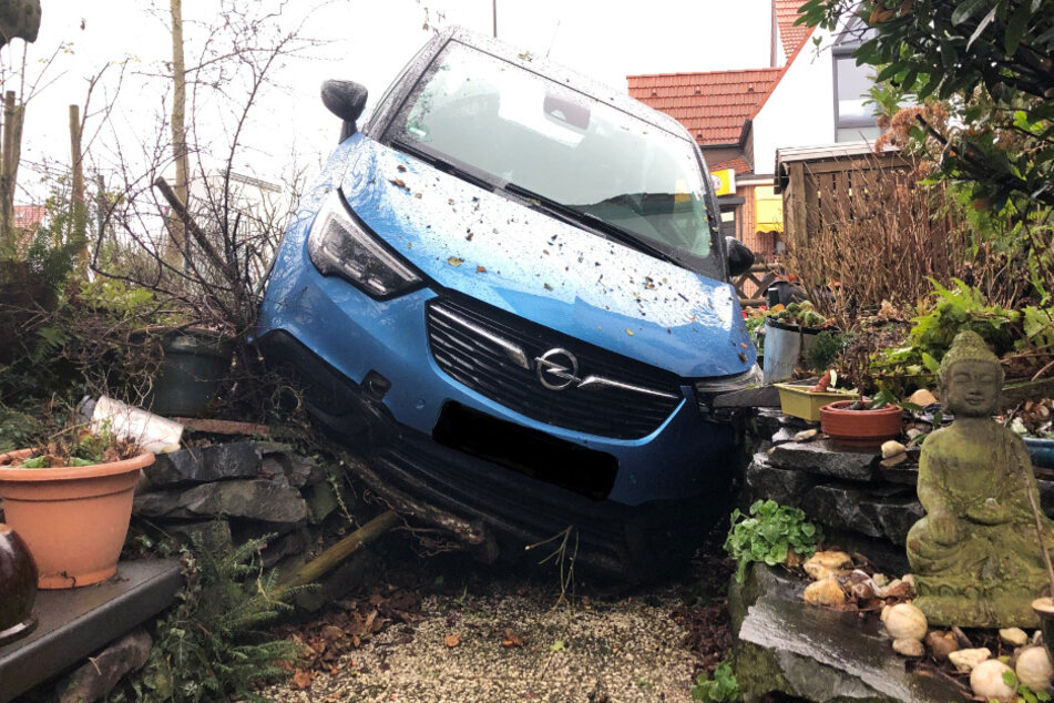 Das Foto zeigt das verunglückte Auto in dem Garten.